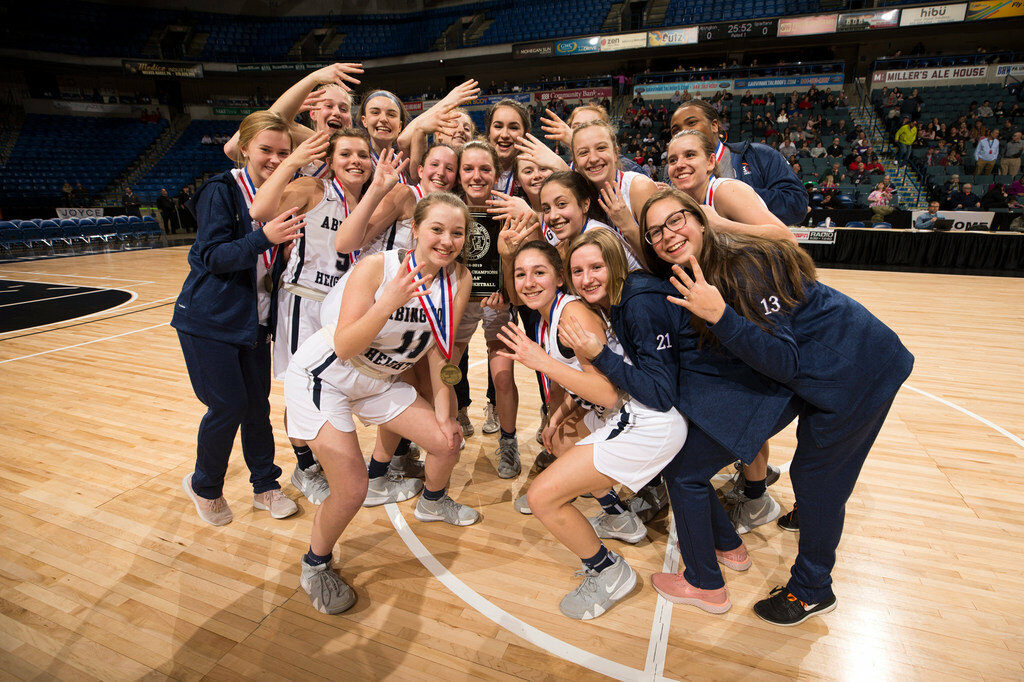 Girls basketball players celebrating a championship win.