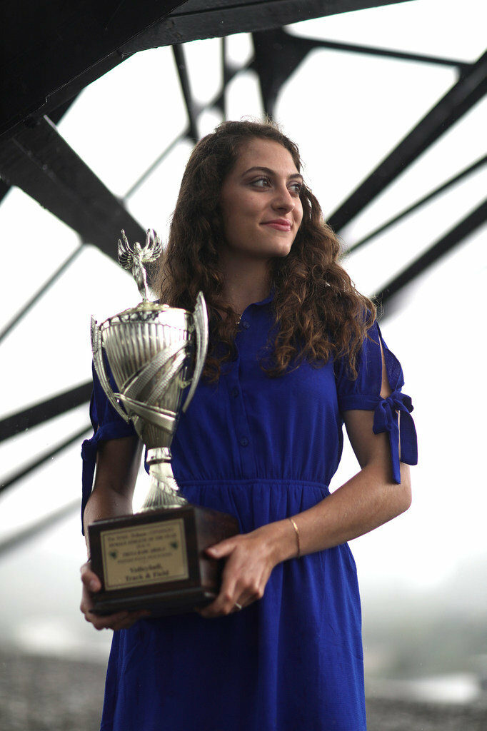 Female athlete holding trophy.