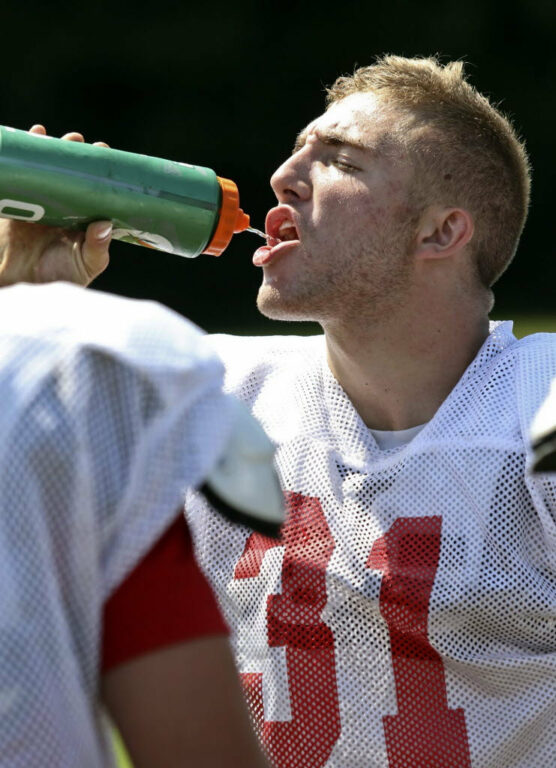 Football player taking a drink.
