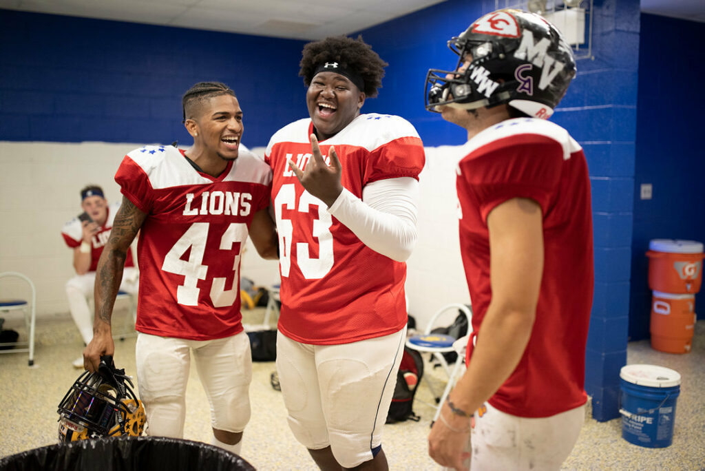Football Players laughing in locker room.