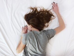 woman sleeping on white sheets