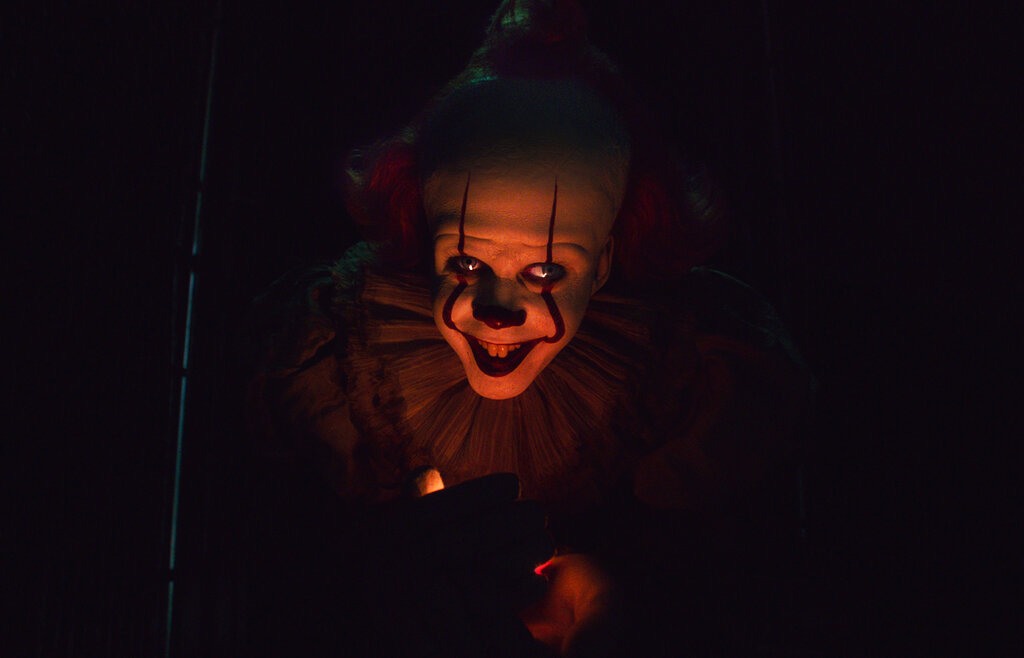 A creepy clown smiles.