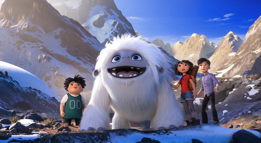 A boy, a Yeti, a girl and a teen boy stand on a mountainside.