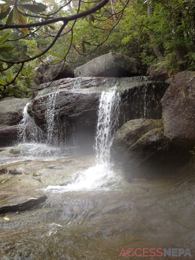 Three streams run through rocks atop Wolf Creek Falls.