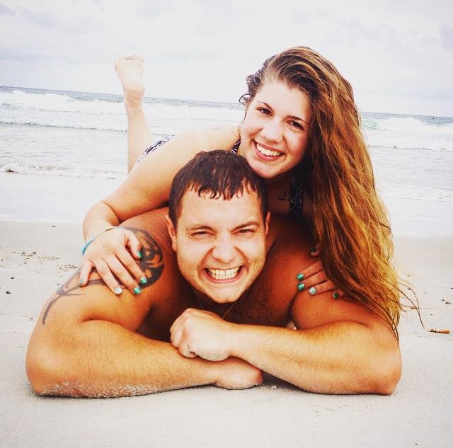 A smiling couple lay on the beach