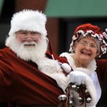 Santa and Mrs. Claus wave from a sleigh