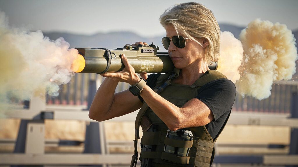 A woman fires a bazooka on a freeway.