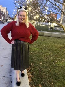 Woman outside in red sweater and black skirt