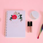 flat lay of notebook and beauty products