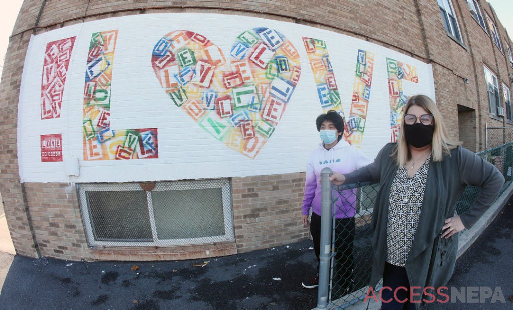 Artist sends !LOVE to her community on a mural at community center